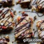 Nutrient-Dense Raw Almond Butter Superfood Bars 10 Raw Almond Butter Superfood Bars with chocolate drizzle on parchment paper