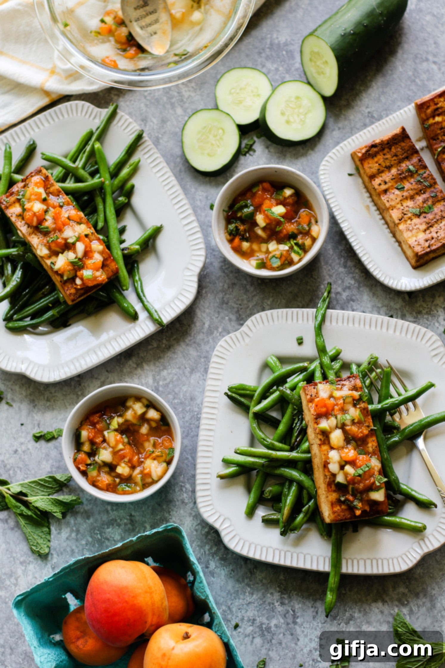Tofu Steaks with Zesty Apricot Cucumber Mint Relish 64 Tofu Steaks served on plate with Apricot Cucumber Mint Compote over green beans with forks