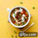 Sunkissed White Bean Chili 9 A rustic mug filled with Summertime White Bean Chili, topped with fresh green onions and a dollop of vegan yogurt