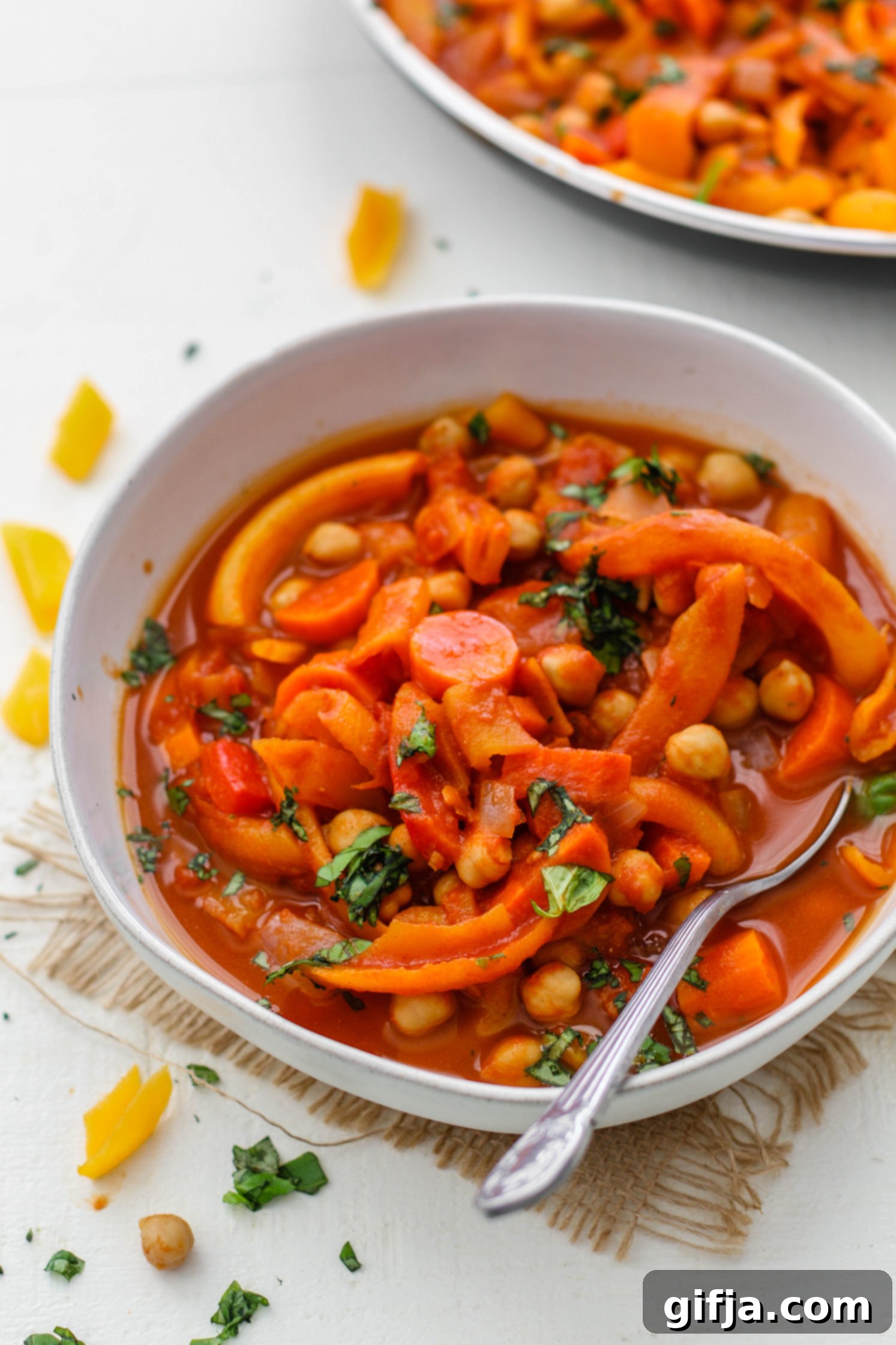 Fragrant Five-Spice Squash and Chickpea Simmer 67 Rich, vibrant 5-Spice Squash & Chickpea Stew served in a rustic bowl, garnished with fresh herbs, with a spoon ready for a comforting bite