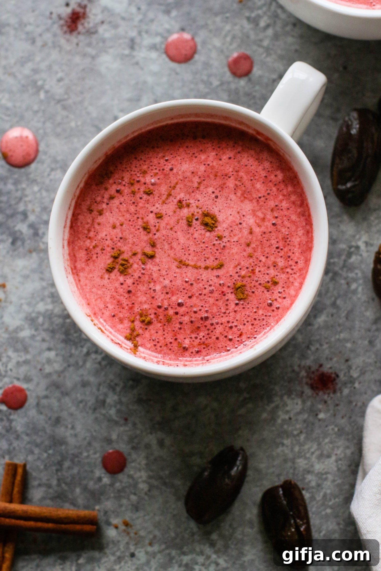 Two mugs of Date-Sweetened Beet Latte, garnished with cinnamon