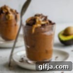 Decadent Chocolate Avocado SunButter Pudding 11 Chocolate Avocado SunButter Pudding in a jar with a spoon.