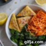 Vibrant Tahini Tempeh and Sweet Potato Noodle Bowl 10 Close up of a Tahini Tempeh & Sweet Potato Noodle Bowl served in bowl with lemon and tahini
