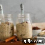 SunButter Raisin Swirl Overnight Oats 11 Oatmeal Raisin SunButter Overnight Oats in a small jar with a spoon, topped with extra raisins and granola