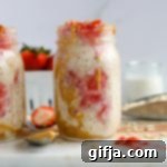 Pure Peanut Butter Overnight Oats 10 Peanut Butter & No-Jelly Overnight Oats in a mason jar, on a marble board with a spoon and smashed strawberries