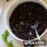 Jammed Yam Imposter 12 Cooked black beans in a pot with cilantro, ready to be served or stored.