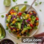 Jammed Yam Imposter 13 Copycat "Jammed Yam" served on plate with spoon, half of a lime, and shredded cilantro with black beans and avocado on the side