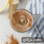 Golden SunButter Spice Smoothie 9 SunButter Cinnamon Smoothie, garnished with a sprinkle of cinnamon, served in a tall glass.
