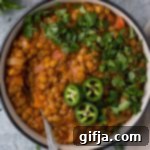 Hearty Lentil Tomato Soup 12 Hearty One-Pot Lentil Tomato Soup with fresh herbs in a bowl, perfect for cozy winter evenings