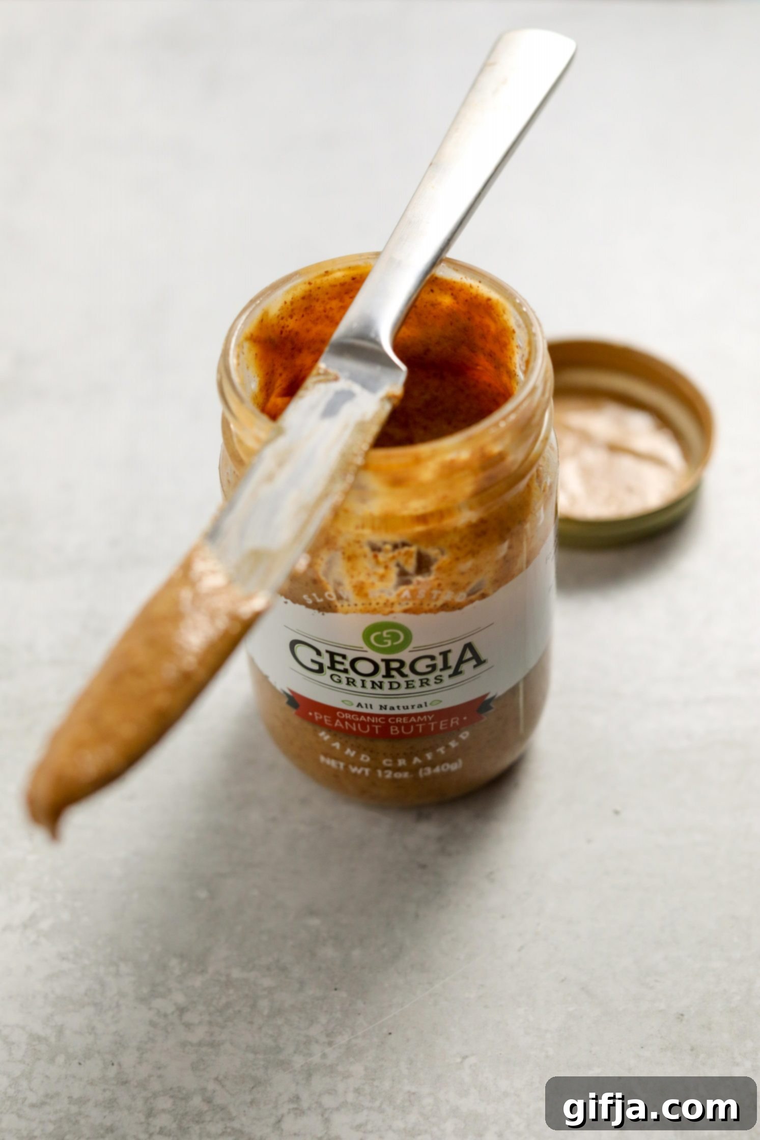 Golden Groundnut Pot 3 Georgia Grinders Organic Peanut Butter opened with a knife by Flora & Vino
