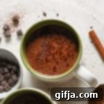 Mexican Spiced Plant-Based Chocolate 9 Two mugs of Vegan Mexican Hot Chocolate with shaved chocolate and cinnamon.