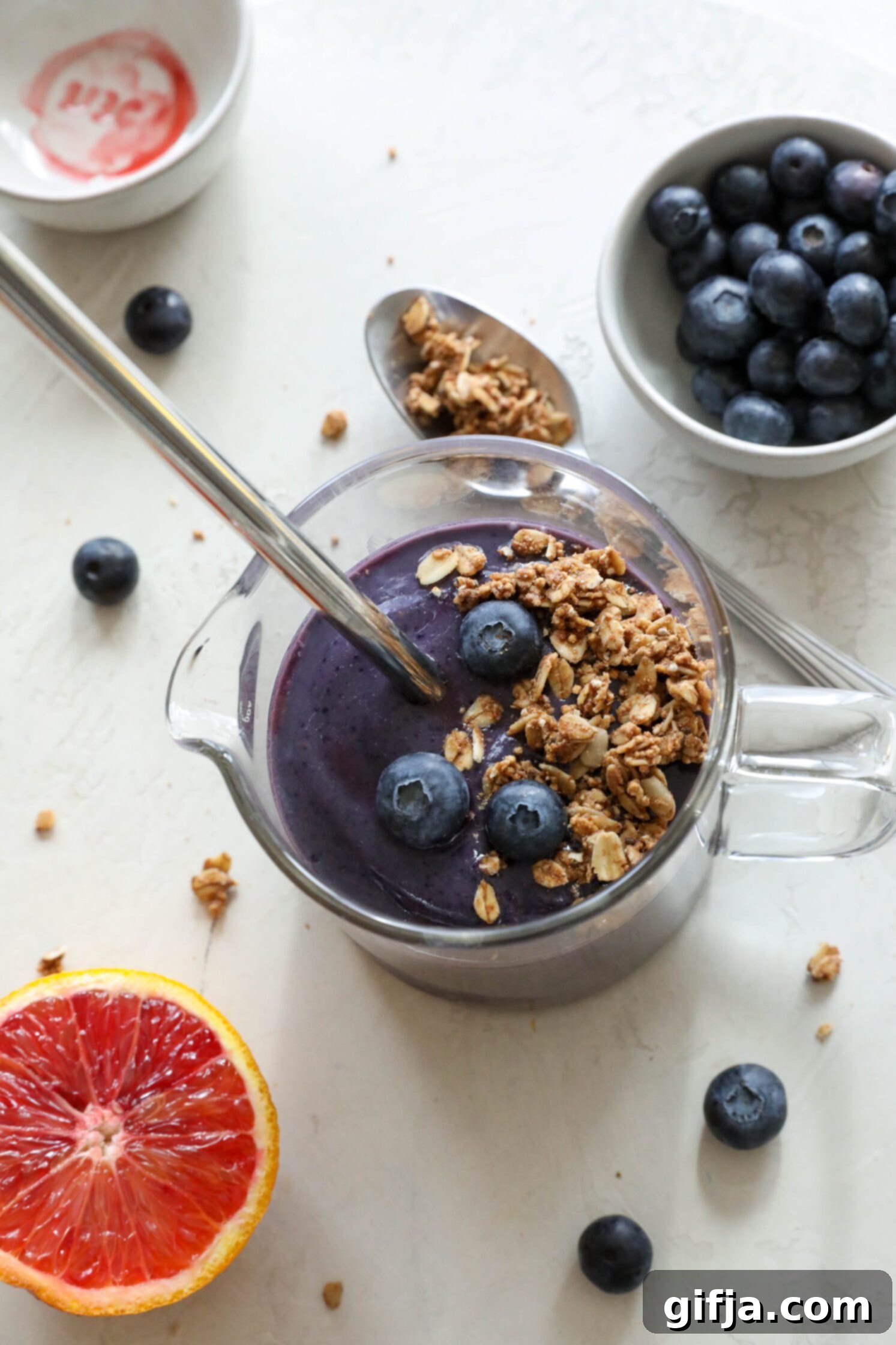 Blood Orange, Beet & Blueberry Fusion 33 Blood Orange Beet Blueberry Shake served in a cup with a metal straw topped with blueberries and granola by Flora & Vino