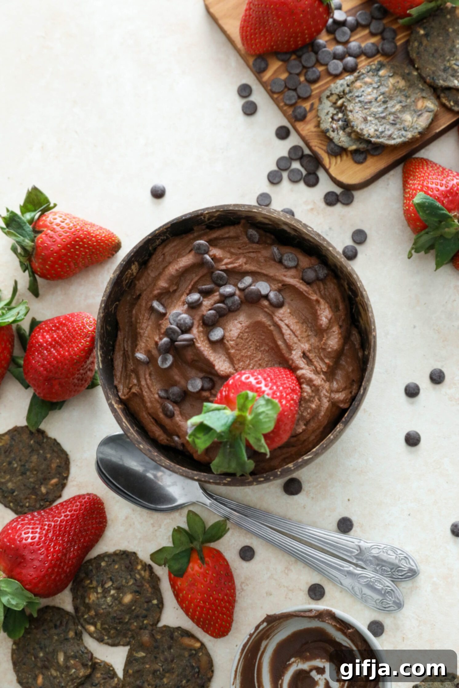 Vegan Brownie Batter Dip served in a bowl topped with dark chocolate chips and strawberries by Flora & Vino