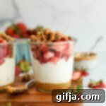 Peanut Butter and Jelly Yogurt Parfait 13 Peanut Butter and Jelly Yogurt Parfait with granola on a wooden board