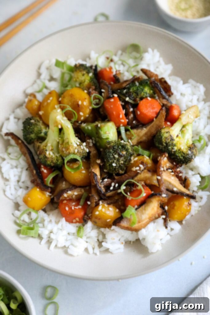 The final delicious serving of Sesame Shiitake & Broccoli Stir-Fry, perfectly presented over jasmine rice, with chopped green onions and sesame seeds, ready to be enjoyed with chopsticks by Flora & Vino.