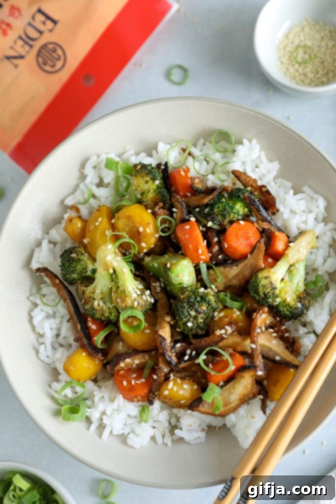 A second appealing shot of Sesame Shiitake & Broccoli Stir-Fry served over jasmine rice with green onion and sesame seeds, emphasizing the inviting presentation and plant-based appeal by Flora & Vino.
