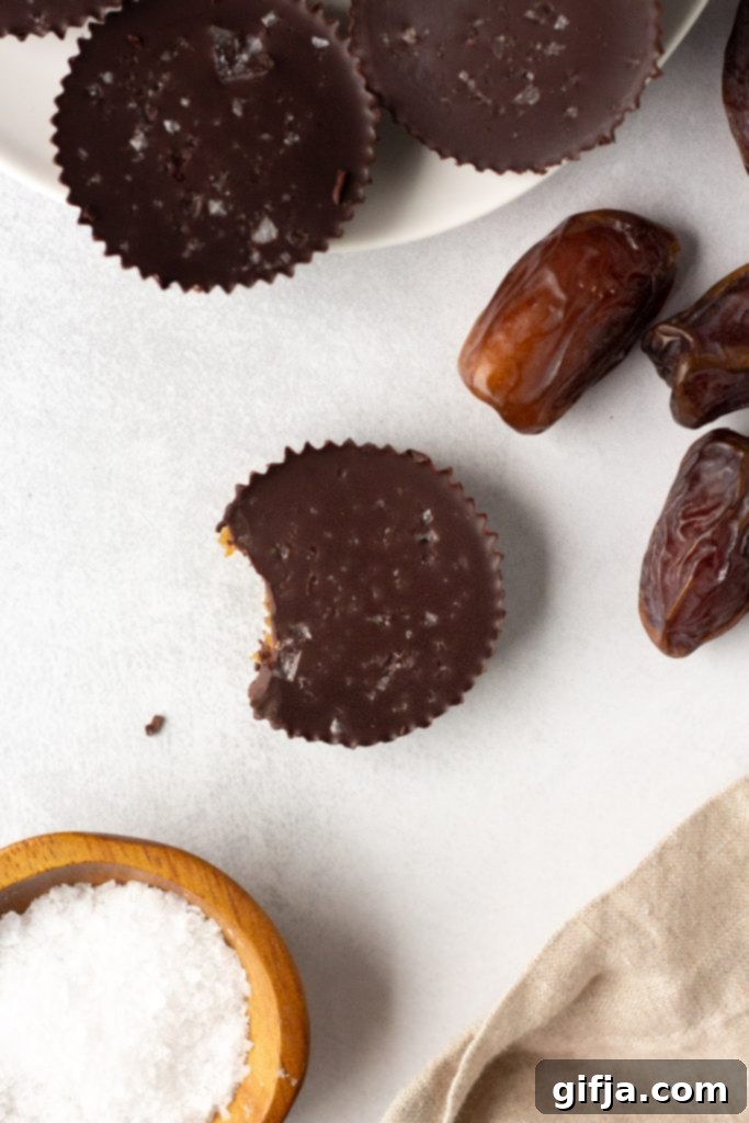 A close-up of a variety of homemade vegan chocolates and caramel cups, perfectly arranged, highlighting their rich textures and decorative toppings, set against a dark, moody background.