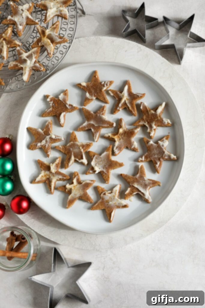 Cinnamon SunButter Star Cookies 11 Cinnamon SunButter Star Cookies (Zimtsterne) served on a plate surrounded by ornaments by Flora & Vino