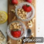 Overnight Strawberry Cheesecake Delight 16 A mason jar filled with strawberry cheesecake overnight oats, topped with fresh strawberries and raw cashews, suggesting a delicious and healthy breakfast.
