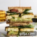 Plant-Powered Breakfast Sandwich 13 Tofu Protein Breakfast Sandwich stacked on plate with toothpick on top