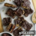 Simply Delicious Nut Free Date Bark 16 Viral Nut-Free Date Bark squares on a parchment-lined wooden board