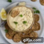Savory White Bean & Cheese Dip 8 Cheezy White Bean Dip in a bowl with crackers and fresh herbs