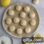 Lemon-Kissed Almond Macarons 12 Lemon Almond Flour Macaroons on a parchment-lined plate