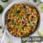 Vegan Mexican Street Corn Salad 11 Vegan Elote Corn Salad served in bowl with spoon surrounded by cilantro and limes