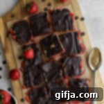 Strawberry SunButter Bark Recipe Card Image Strawberry SunButter Bark on a wooden board with a bowl of strawberries, chocolate chips, and a spoon with SunButter.