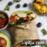 Plant-Powered Breakfast Burrito 15 Miniature image of a Tofu Scramble Breakfast Burrito, cut in half, showcasing its rich, colorful fillings, ideal for quick meal identification.