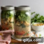 Taste of Thailand in a Jar 14 Close-up of a single Thai Mason Jar Salad, showcasing the vibrant layers of ingredients, topped with fresh cilantro.