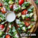 Pizza with Cauliflower Crust 9 A slice of healthy cauliflower crust pizza with arugula, avocado, and tahini drizzle.