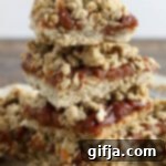 Spiced Apple Butter Crumble Delights 11 Delicious Apple Butter Crumble Bars, stacked neatly on parchment paper, displaying a perfect golden-brown crumble top.