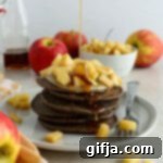 Apple Pie Spiced Vegan Pancakes 12 A stack of fluffy Vegan Apple Pie Pancakes with apple compote on top, ready to be served