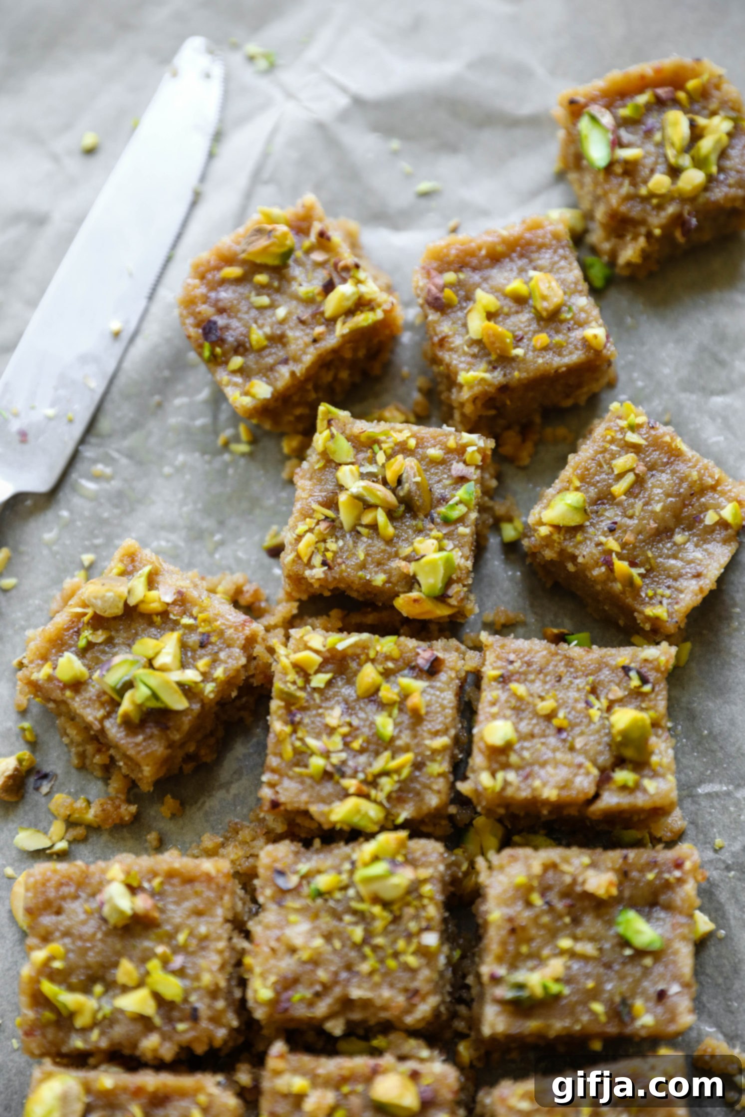 Vegan Tahini Date Halva cut on parchment paper with a knife by Flora & Vino