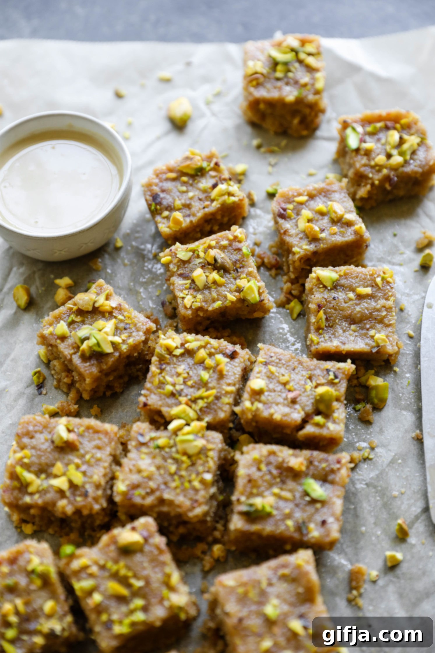 Vegan Tahini Date Halva sliced on parchment paper with tahini by Flora & Vino