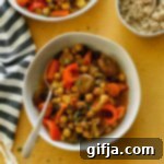 Fragrant Apricot Chickpea Stew 7 Thumbnail image of Curried Chickpea Apricot Stew in a bowl with quinoa, garnished with herbs.