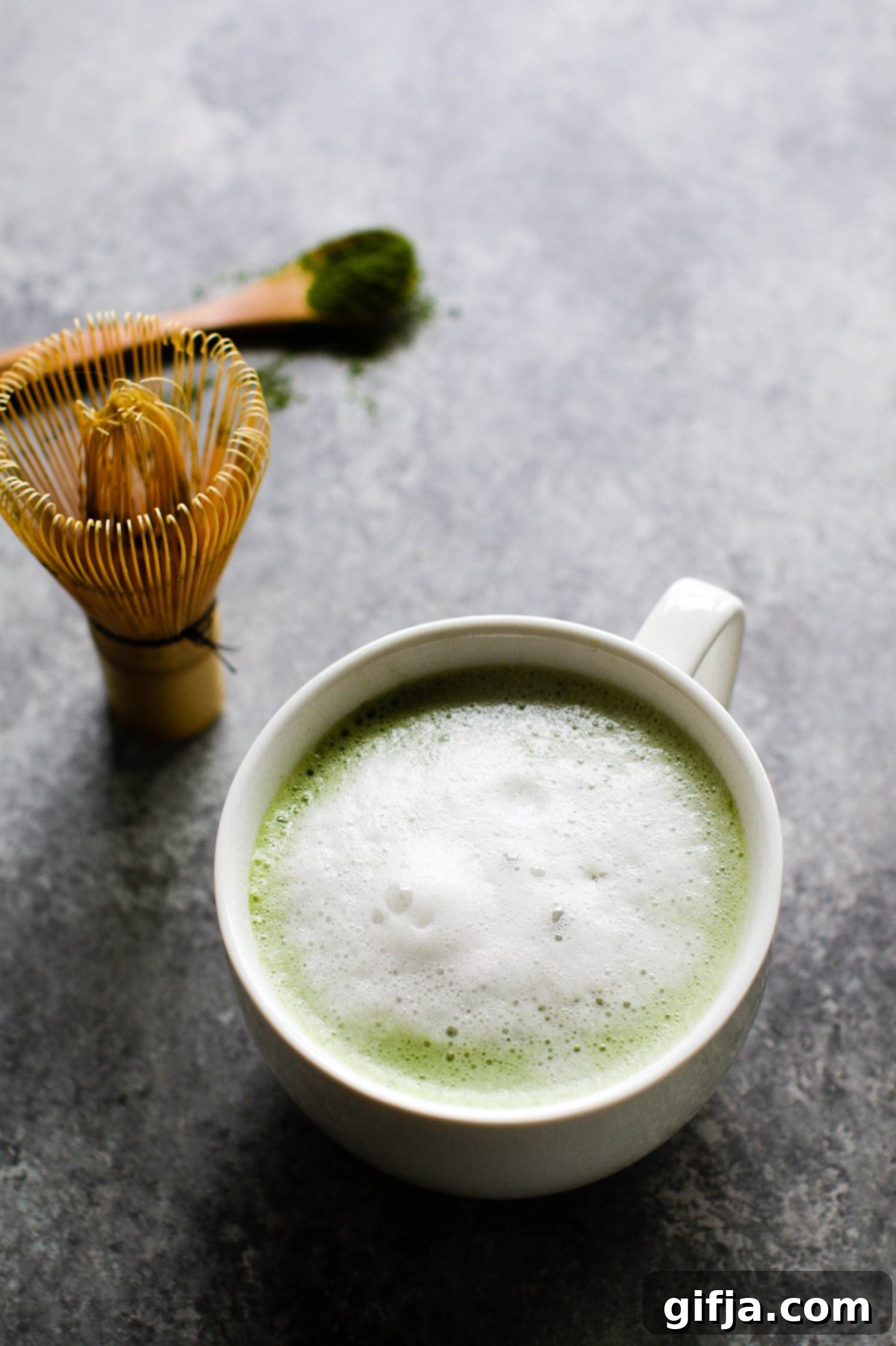 Cinnamon Almond Matcha Latte in mug with milk froth by Flora & Vino