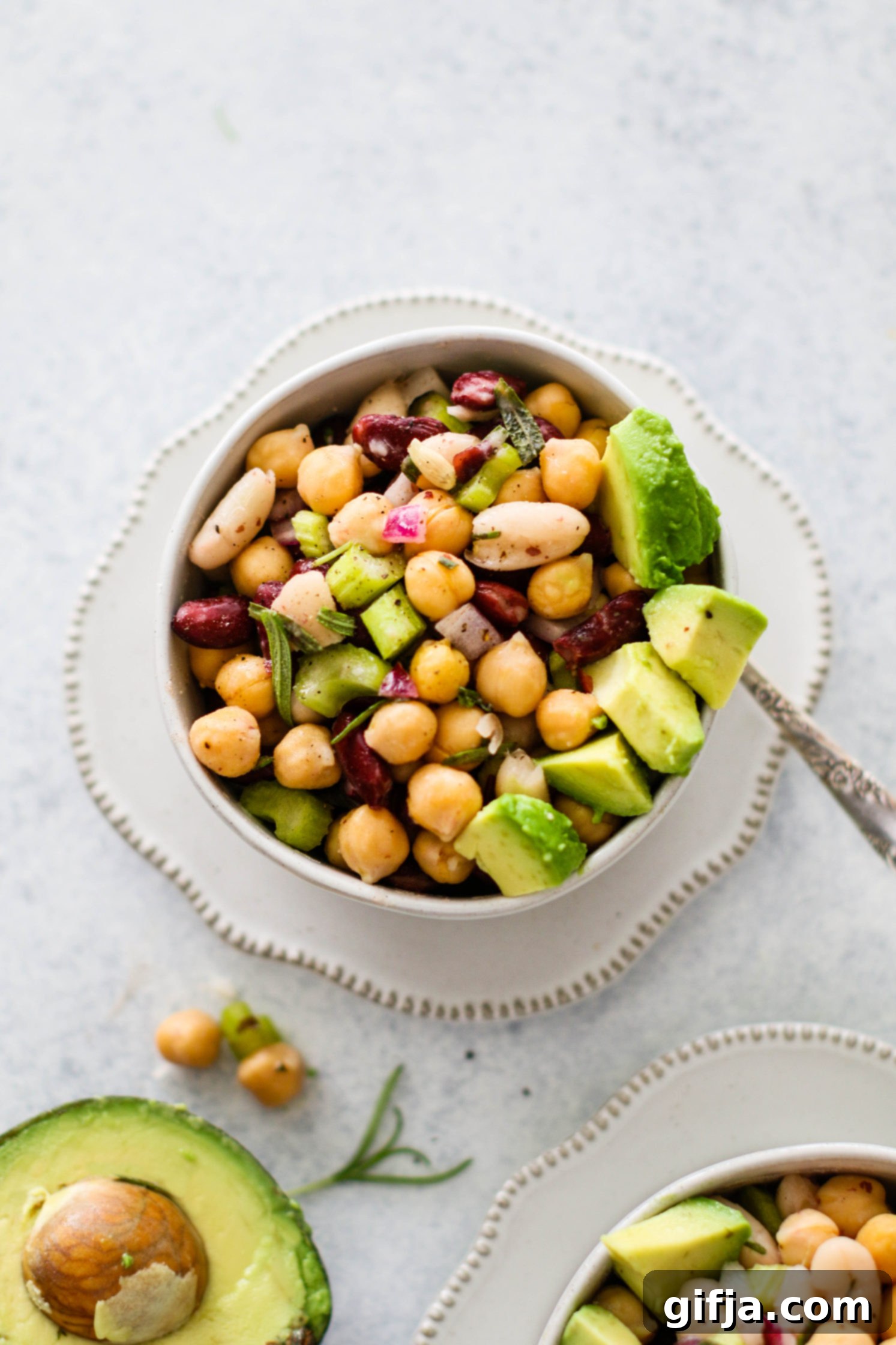 Aromatic Three Bean Medley 16 Rosemary Three Bean Salad served in white bowl with avocado and a spoon