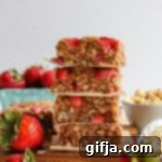 Delicious Baked Peanut Butter & Jelly Breakfast Bars 14 Delicious PB&J Baked Breakfast Bars stacked on a parchment-lined board, ready to be enjoyed