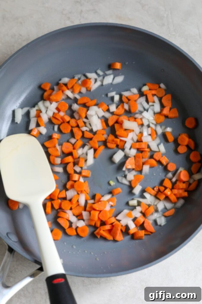 Solo Fried Rice Delight 4 diced white onion and carrots in skillet with spatula