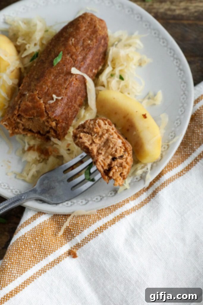 Vegan bratwurst on plate topped with sauerkraut