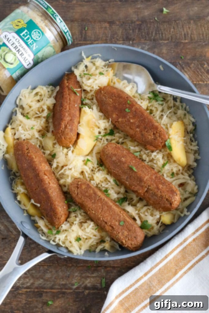 Vegan Bratwurst with Sauerkraut in pan with spoon topped with parsley