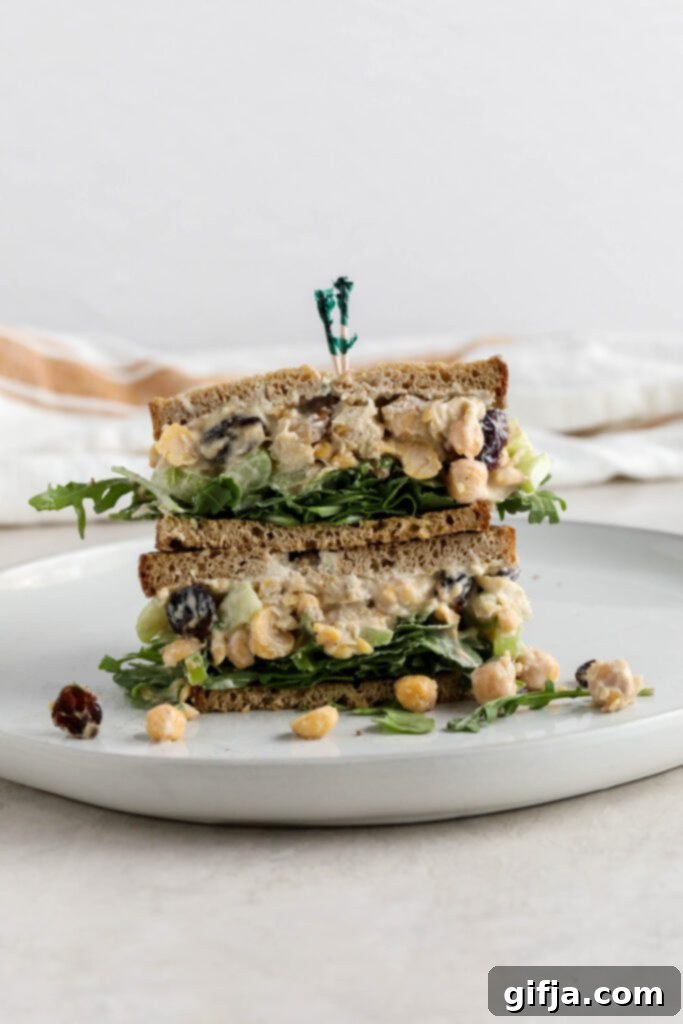Assembled Cranberry Chickpea Salad Sandwich stacked on a white plate