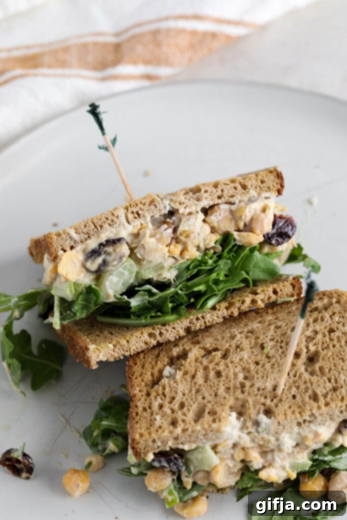 Halved Cranberry Chickpea Salad Sandwich served on a white plate