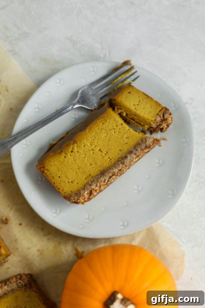 Spiced Pumpkin Cheesecake with Silky SunButter Frosting 13 Pumpkin Pie Cheesecake with SunButter Frosting on plate with fork, close up of a slice