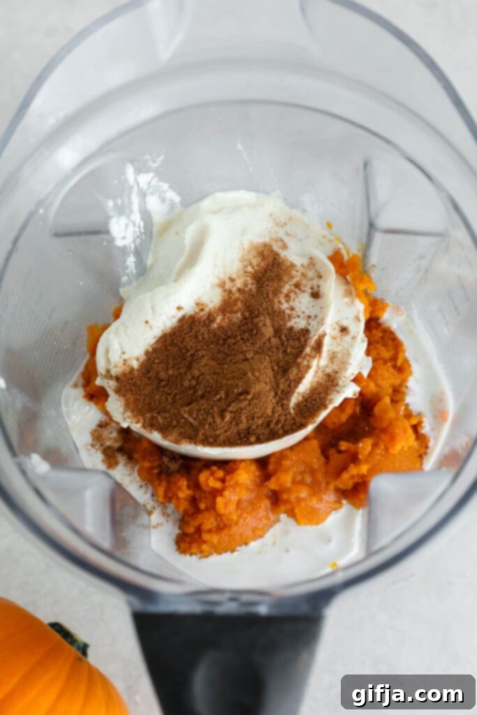 Spiced Pumpkin Cheesecake with Silky SunButter Frosting 5 ingredients for pumpkin pie filling in blender, showing cashews, pumpkin puree, and spices