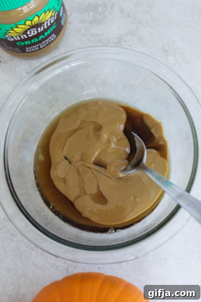 Spiced Pumpkin Cheesecake with Silky SunButter Frosting 8 SunButter and maple syrup mixed together in glass bowl, forming the frosting