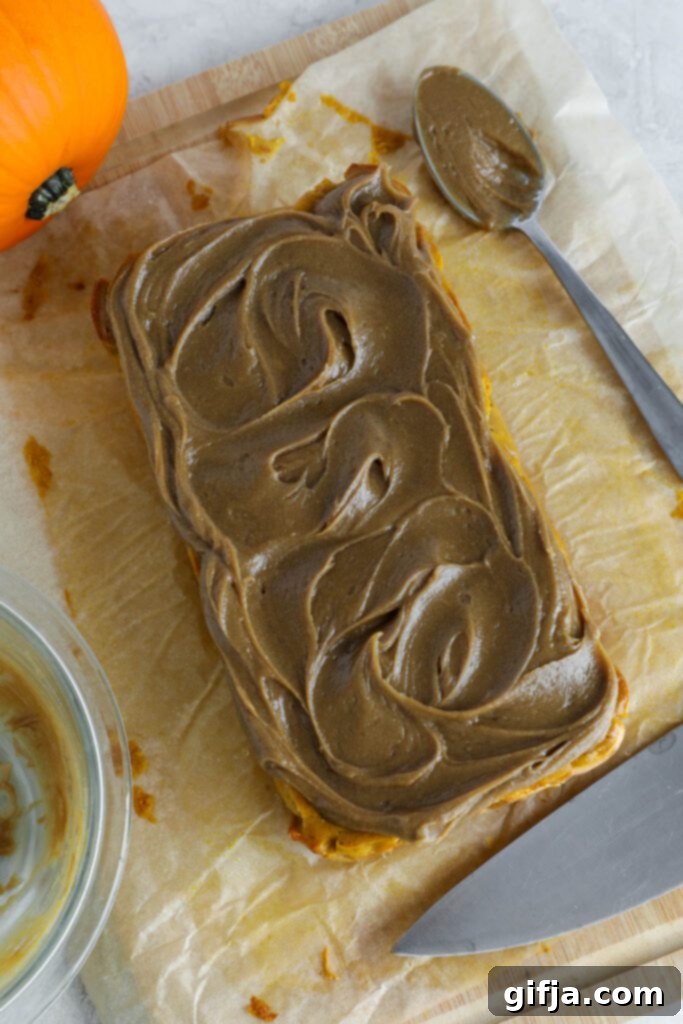 Spiced Pumpkin Cheesecake with Silky SunButter Frosting 10 SunButter frosting on top of pumpkin cheesecake on parchment paper with knife, ready to be sliced