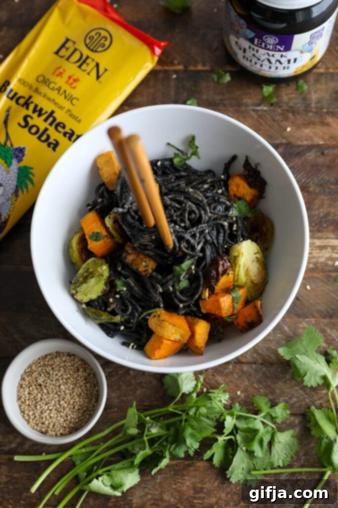 Midnight Sesame Noodle Bowl 11 Black Sesame Noodle Bowl served in a bowl, garnished with cilantro and sesame seeds, captured from a closer perspective.